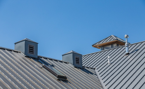 The picture shows the top of a building's metal roof, which offers many benefits for those looking for a long term solution.