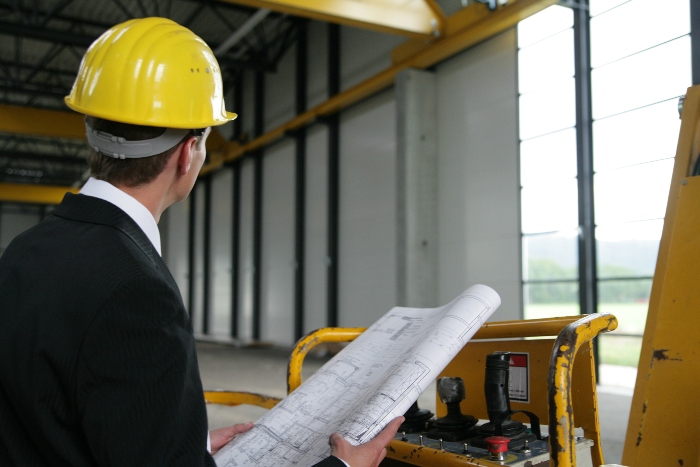 A contractor makes sure a pole barn is up to building codes and local regulations after getting the required permits.