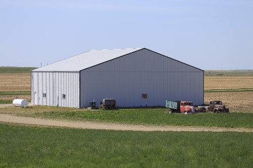 A post frame structure has been used for the pole barn in this picture.