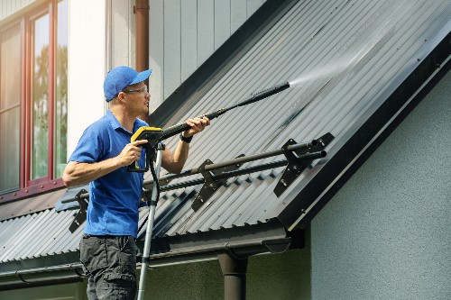 A metal roof maintenance worker services a metal roof.