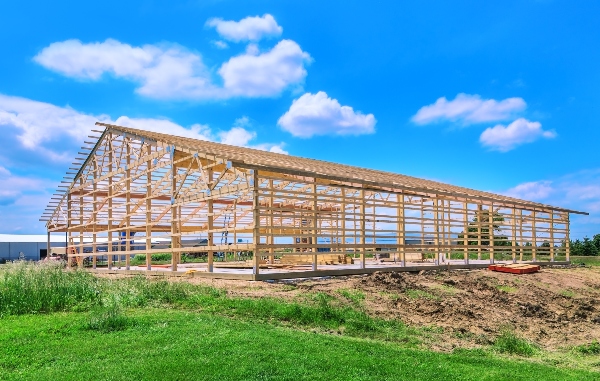 Building a pole barn can be simple if your contractor takes the right steps. This frame of a pole barn stands ready for its metal panel exterior.